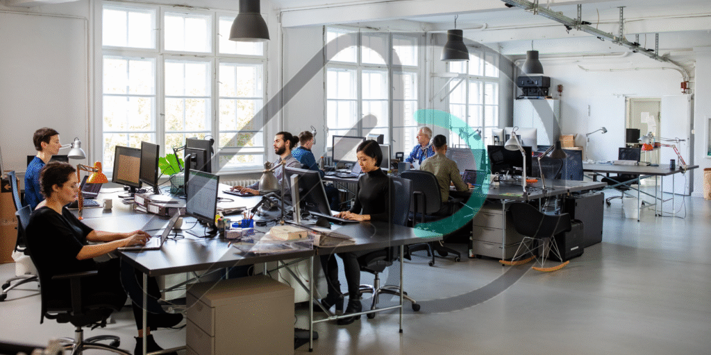 A bustling open-plan office with employees working at their desks. This image illustrates a guide to social media advertising services in the US.